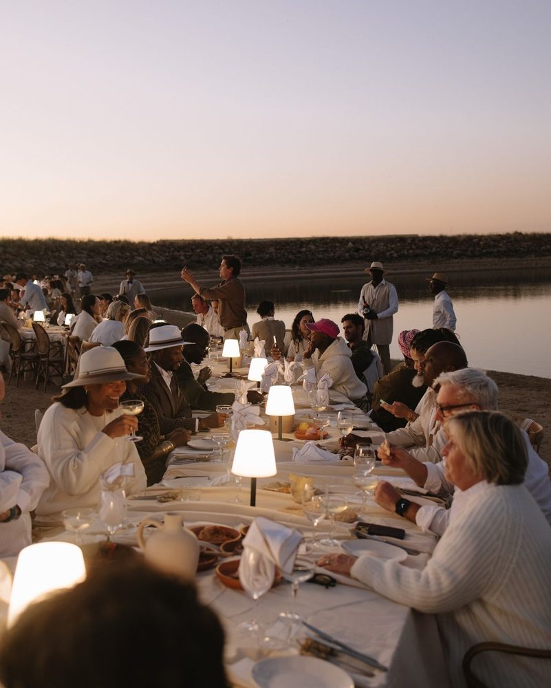 Longue table de dîner au bord de l'eau au crépuscule