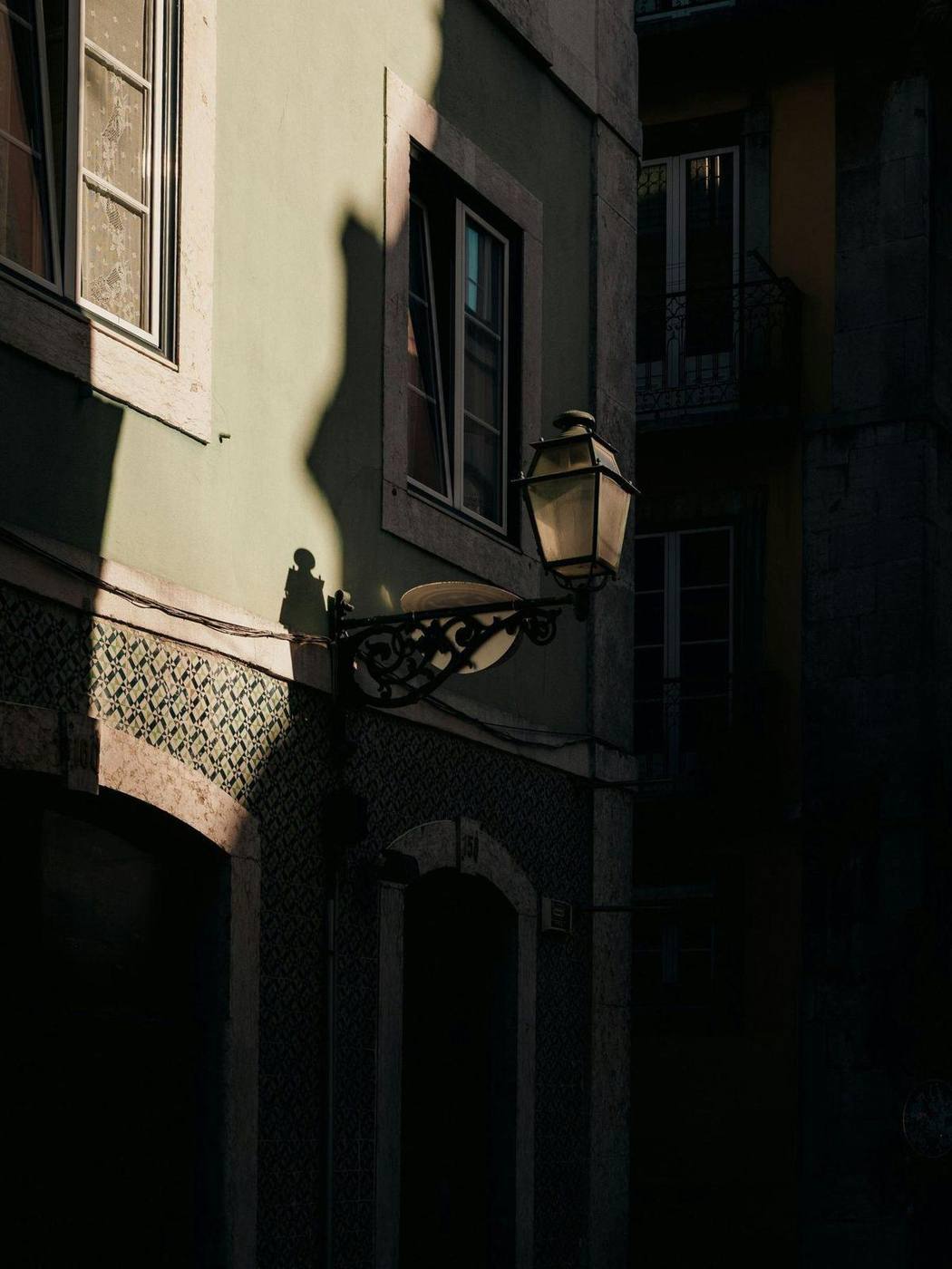 Lumière du soir sur une façade d'azulejos et une lanterne de rue, Lisbonne